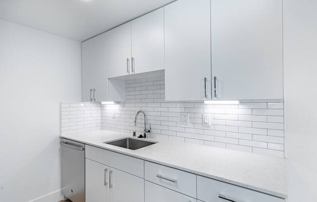 a white kitchen with white cabinets and a sink at Avenue Two Apartments, Redwood City  , California