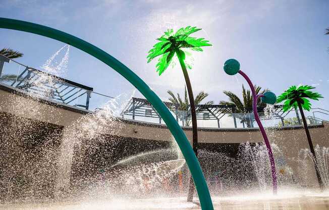 A water fountain with a green palm tree in the background.