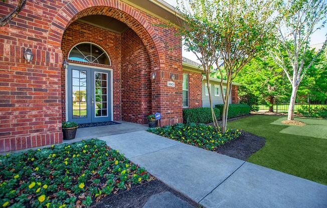 a garden in front of a brick building