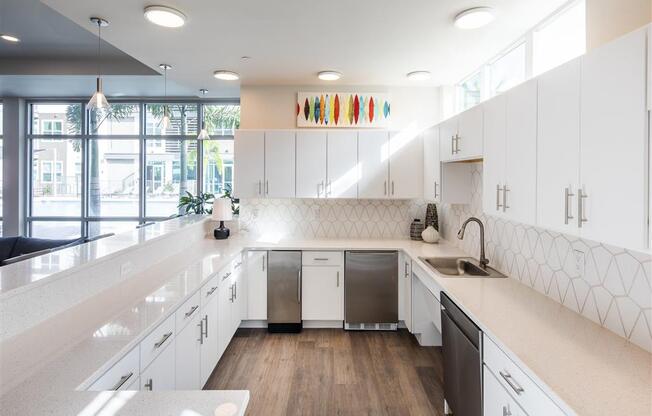 a large white kitchen with white cabinets and a sink