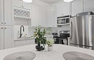 A modern kitchen with a stainless steel refrigerator and a white countertop.