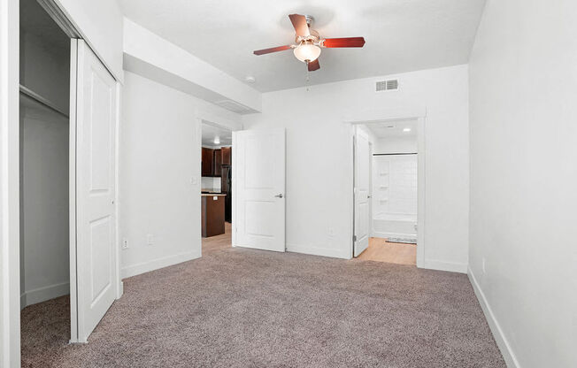 an empty living room with a ceiling fan