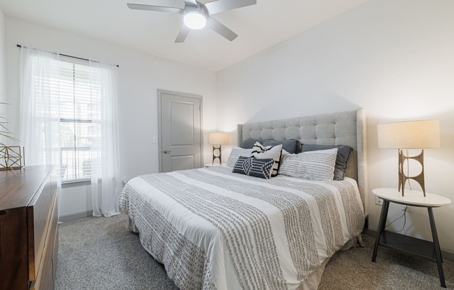 a bedroom with a bed and a ceiling fan