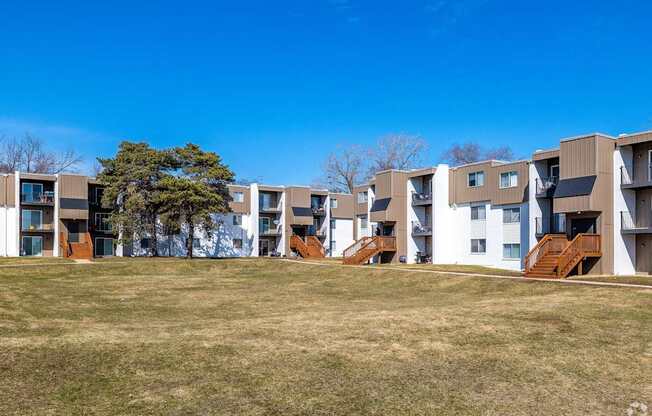 a row of apartment buildings on a hill with grass