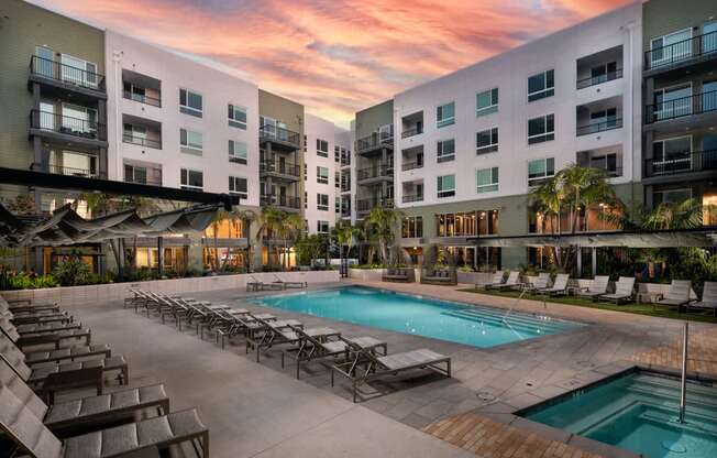 A large outdoor swimming pool surrounded by lounge chairs and umbrellas.