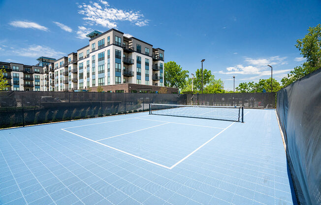 a tennis court with a building in the background