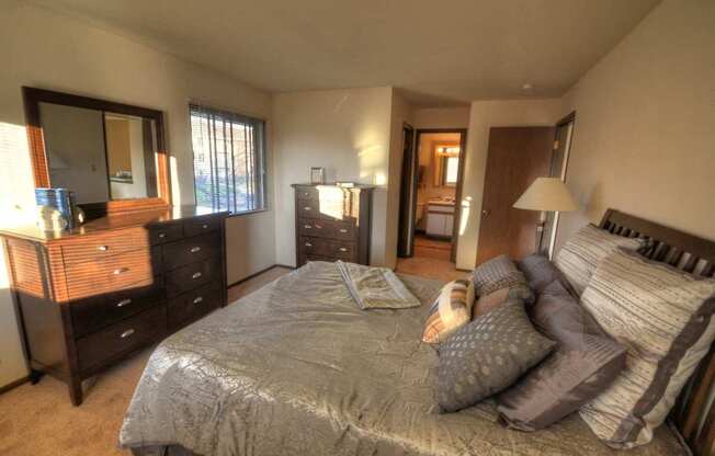 a bedroom with a bed and a dresser and a mirror