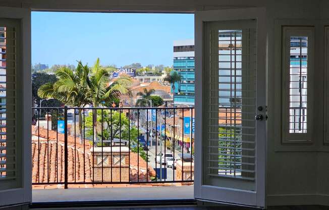 the view from the window of an apartment in a building with palm trees