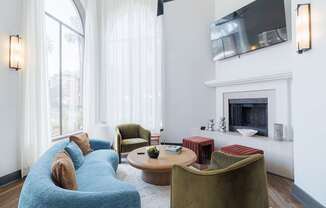 A living room with a blue couch and a fireplace.