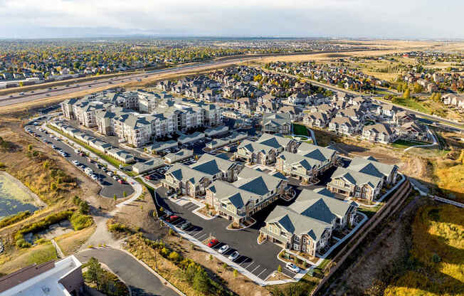 A large housing development with multiple buildings and a parking lot.
