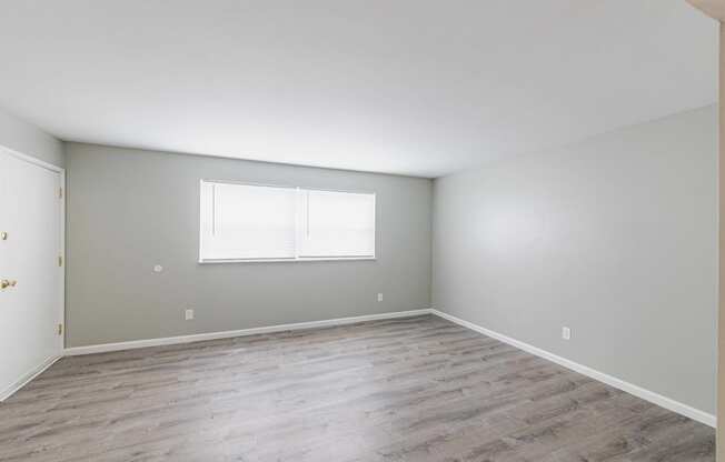 a bedroom with hardwood floors and grey walls