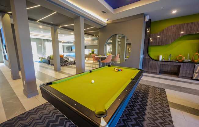 a pool table in a clubhouse with a yellow ball on it