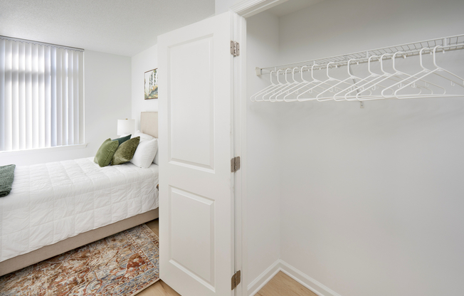 This spacious walk-in closet is upgraded with new vinyl plank wood-style flooring, providing a clean and modern look that extends from the primary bedroom.