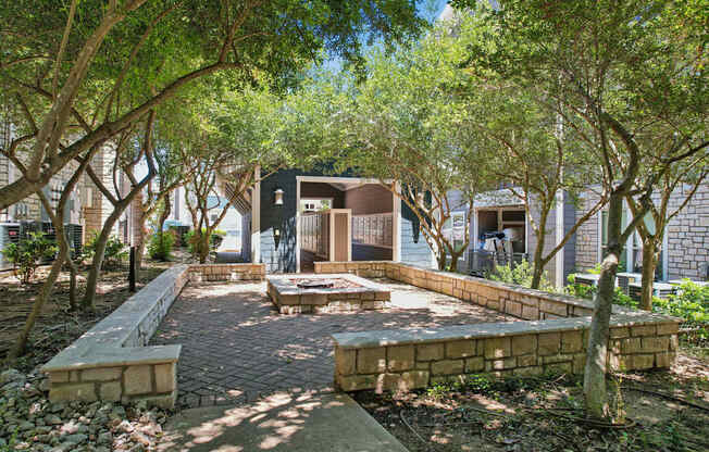 A courtyard surrounded by trees and a brick pathway.
