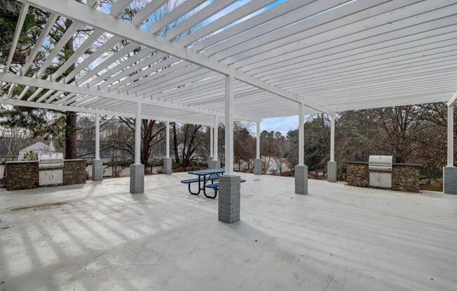 a covered patio with a table and a bench under a white roof  at The Sapphire, Decatur, GA