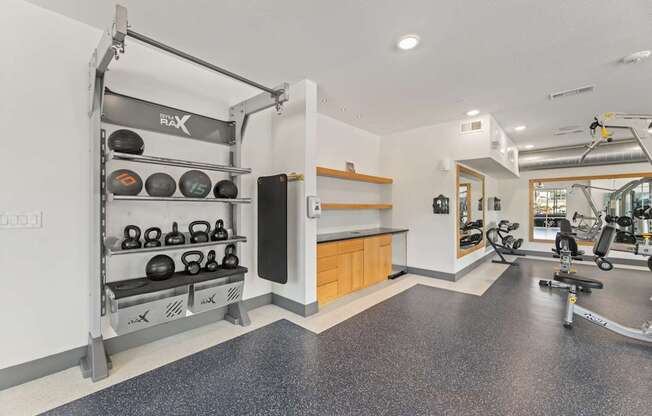 A gym with a weight rack and exercise equipment.