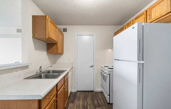 a kitchen with white appliances and wooden cabinets