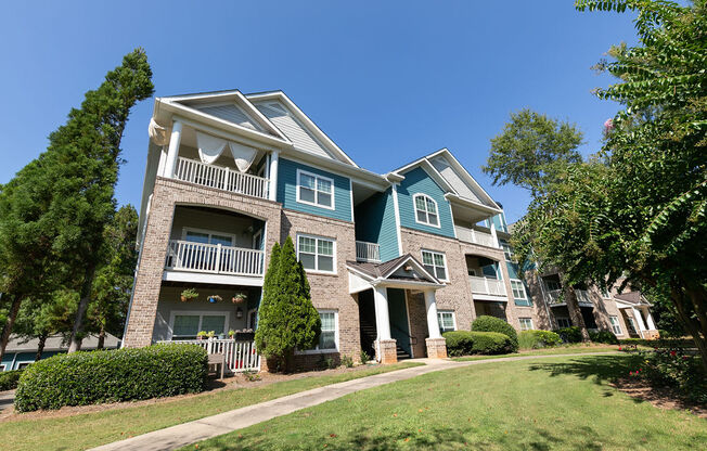 an apartment building with green grass and trees