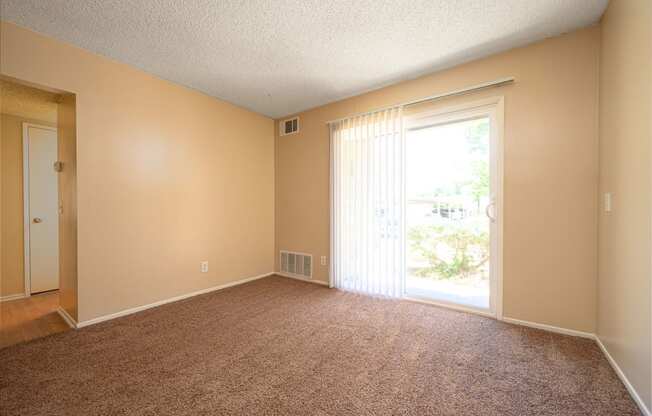 a bedroom with a sliding glass door and a carpeted floor at Oak Terrace Senior Apts, California, 92543