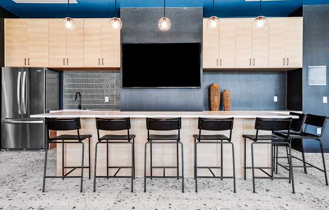 A kitchen with a bar area featuring a counter and chairs.