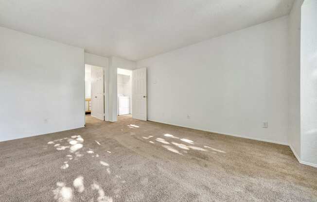 an empty living room with white walls and carpet