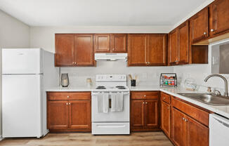 a kitchen with wooden cabinets and white appliances