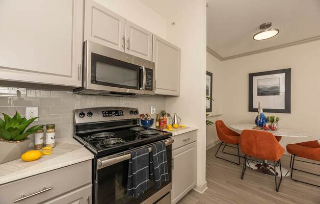 Kitchen with a black stove at Woodbridge Villas Apartments, Texas