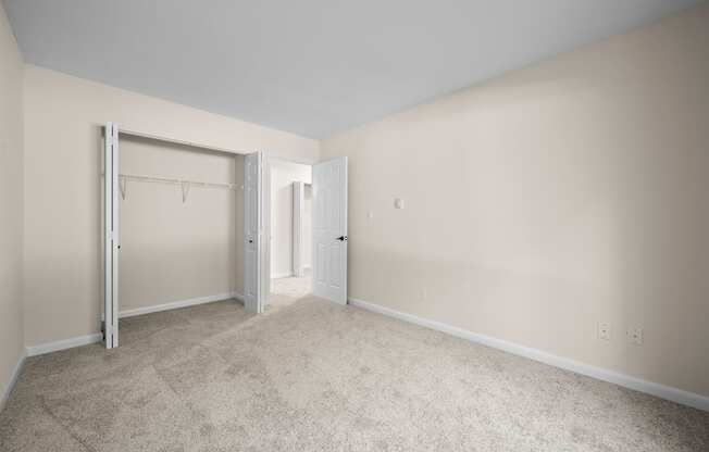 A room with a carpeted floor and two doors.