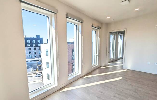 a living room with large windows and a wood floor