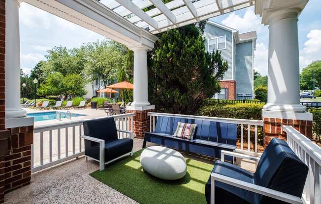 a covered patio with couches and chairs near a pool