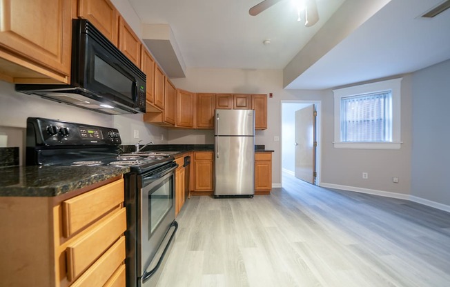 A kitchen with wooden cabinets and a black countertop.
