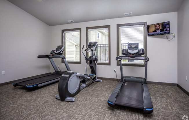 Modern gym with rows of cardio equipment.