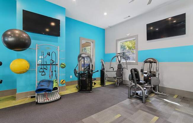 A gym with a variety of equipment including a weight bench, a leg press machine, and a cable machine.