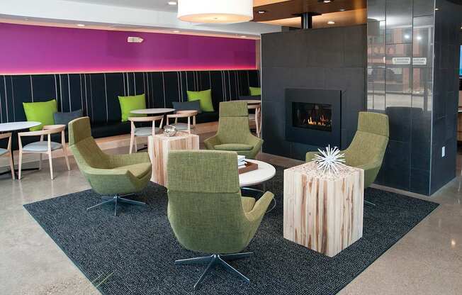 A sitting room with a fireplace and green chairs.