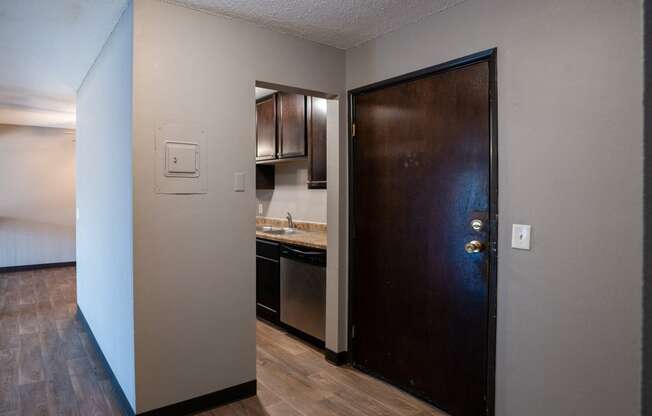 an open door leading into a kitchen with a sink and a refrigerator. Roseville, MN Rosedale Estates Apartments