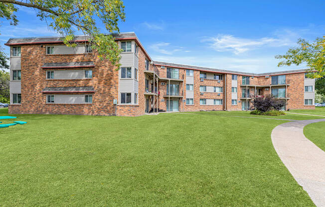A large grassy area in front of a brick building.