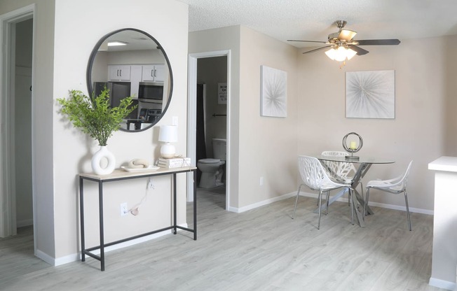 a living room with a mirror and a dining room table