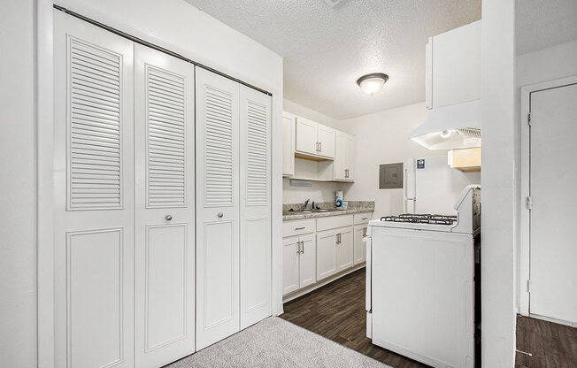 a renovated kitchen with white cabinets and a stove and a sink