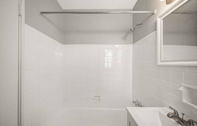 a white bathroom with a shower and a sink