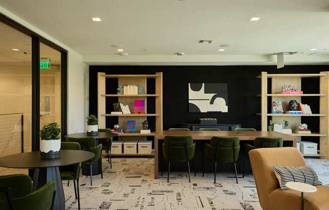 A room with a black and white patterned carpet and a variety of chairs and tables.