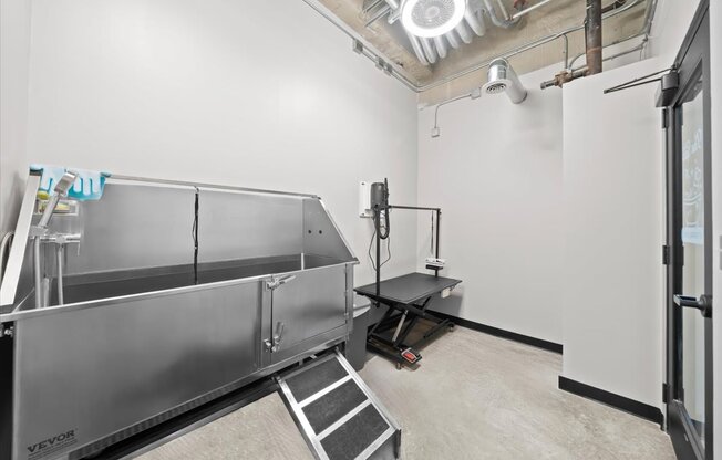 A large industrial-style freezer is in a room with a white wall and a black table.