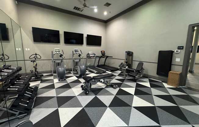 A gym with a variety of exercise equipment.