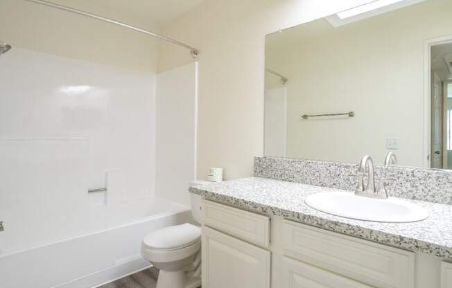 A white bathroom with a sink, toilet and bathtub.