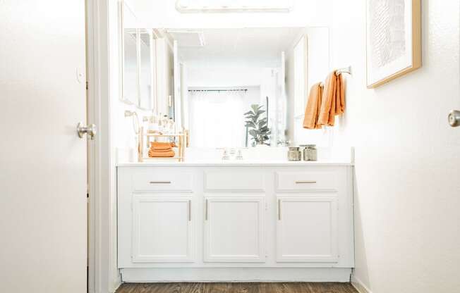 a bathroom with white cabinets and a sink and a mirror