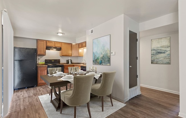 A kitchen with a dining table and chairs.