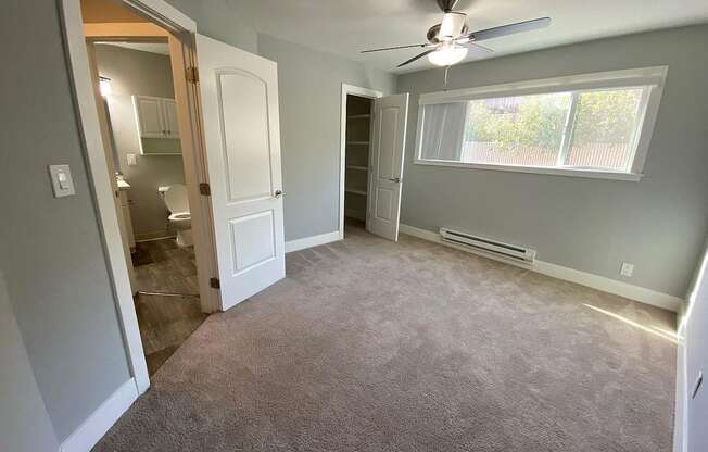 A room with a ceiling fan and a window.