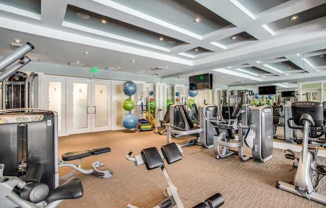 a gym with cardio machines and weights on the floor