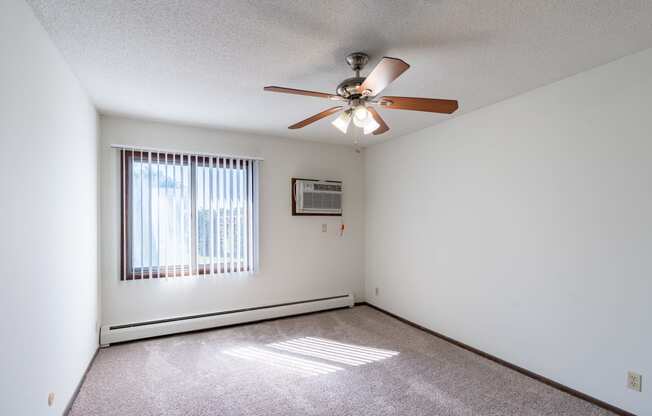 a bedroom with a ceiling fan and a window. Eagan, MN Glen Pond Apartments