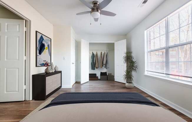 an empty bedroom with a ceiling fan and a bed