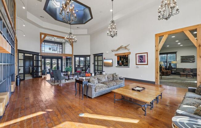 A living room with a wooden floor and a large chandelier.